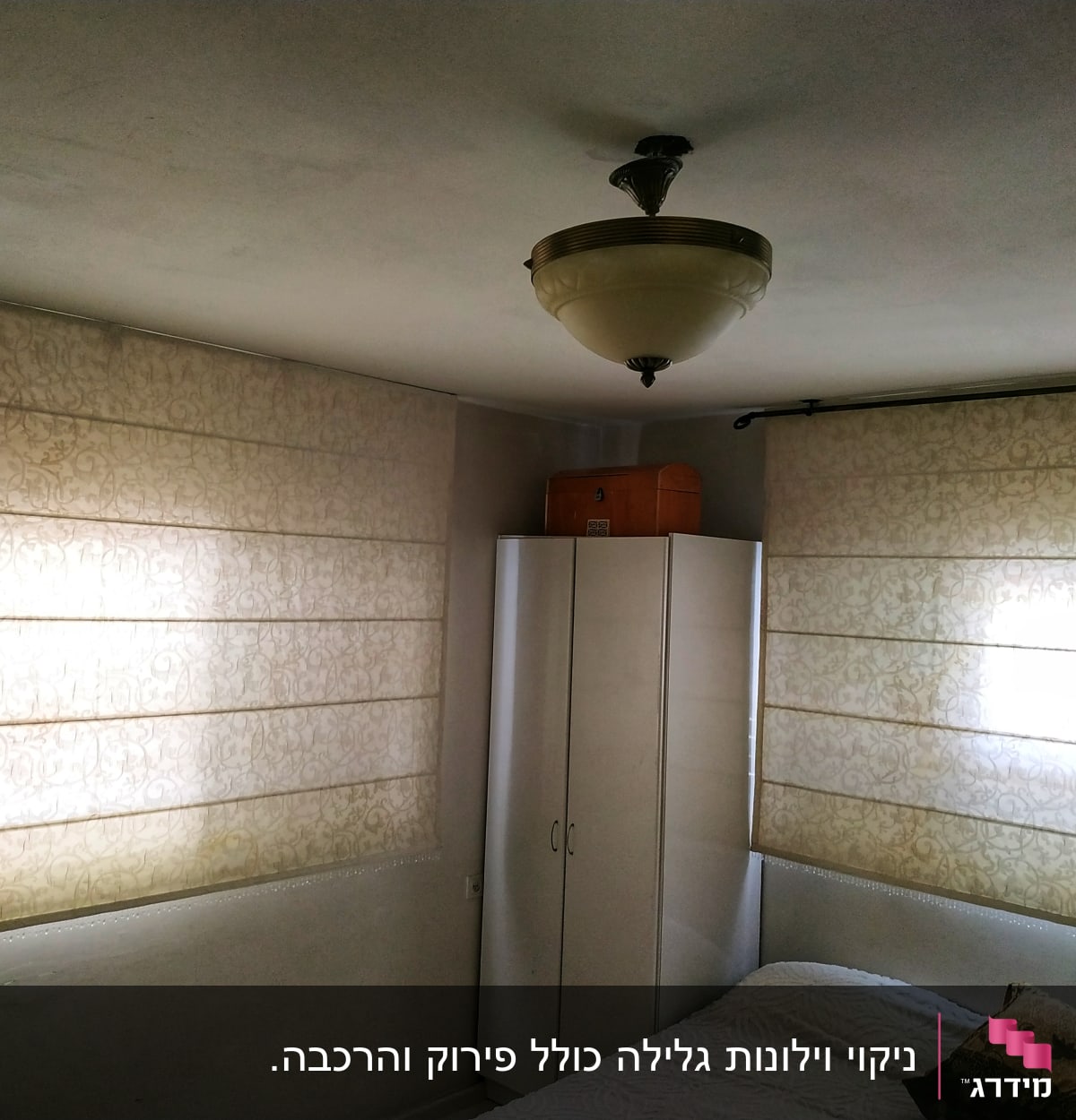 Two beige Roman blinds with floral patterns covering windows in a room.
